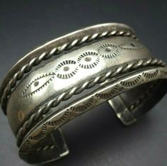 "VINTAGE NAVAJO BRACELET DESCRIPTION: This old hand wrought Navajo cuff bracelet features intricate designs. The hand-stamped edges are carinated, and thick twisted silver wire serves as an additional border. From the Frank Kinsel collection, this collectible bracelet will be a cherished addition to your collection of the very finest vintage Native American jewelry. MEASUREMENTS: Interior of the cuff measures 5 1/2\" with an additional 1 1/8\" slightly adjustable gap. Total circumference: 6 5/8\ Adjustable Stamped Antique Silver Cuff Bracelet, Antique Engraved Cuff Bracelet, Vintage Stamped Cuff Bracelet For Wedding, Antique Silver Stamped Cuff Bangle, Vintage Etched Cuff Bangle, Vintage Ceremonial Stamped Cuff Bracelet, Traditional Stamped Cuff Bangle, Vintage Oxidized Bangle Cuff Bracelet, Vintage Stamped Cuff Bracelet Bangle