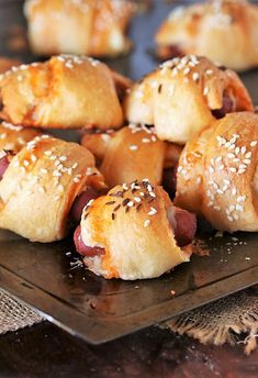 rolls with sesame seeds and ham in them on a plate