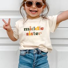 Middle Sister Shirt, Newborn Announcement Siblings Matching Shirts Kids, Pregnancy Announcement, Boho 3rd Baby Announcement Little Sister 🌸 Soft & Lightweight Material - Graphic tees for women are made from a soft, lightweight, and stretchy fabric that provides a familiar and comfortable feel. You'll love wearing it all day long. 🌸 GREAT GIFT:  Good choice as a gift for your mom, sister, your wife or anyone you want to send a gift.  🌸 Wash: Recommended machine/hand wash and wash inside out and line dry. PLEASE DON'T Put IT IN THE DRYER, DRY CLEAN, or BLEACH. ♥️Designed and Handmade in the USA♥️ Cute Family Tops, Cute Unisex Tops For Family, Cute Family T-shirt With Letter Print, Family Multicolor Letter Print T-shirt, Family Occasion Multicolor Letter Print T-shirt, Multicolor Letter Print T-shirt For Family, Cute Tops With Funny Text For Family Events, Cute Tops With Funny Text For Family, Cute Family Shirt With Letter Print