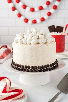 a cake with marshmallows and chocolate frosting on top is sitting on a plate