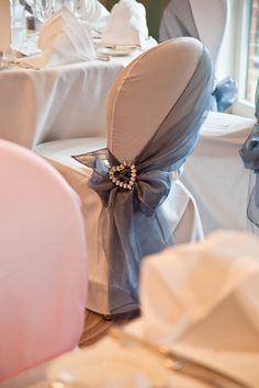 the back of chairs with bows on them are decorated in blue and white color scheme