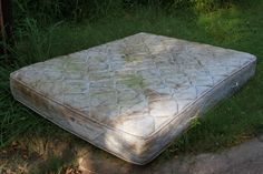 an old mattress is laying in the grass