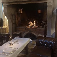 a dining room with a fire place in the fireplace and two leather chairs around it