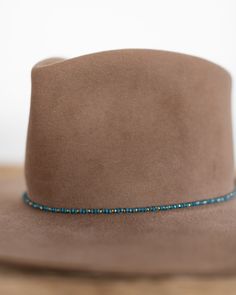 This hat band mixes beautiful faceted glass beads with brass accents to create a subtle sparkle to add to your hat. Material: Faceted glass beads & brass beads Dimensions: 21" beaded length Closure: Adjustable slide closure Color Options: Black, Gray, Beige, Blue Handmade by Crossbow in the mountains of Telluride, CO. Glass Hat, Beaded Hat Bands, Beaded Hat, Brass Beads, Belt Purse, Crossbow, Accessories Bags Purses, Brass Accents, Hat Band