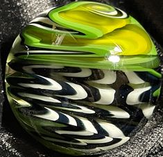 a green and black glass object sitting on top of a table