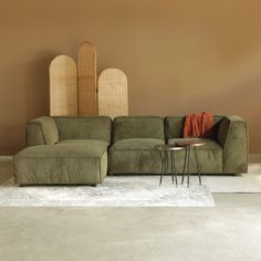 a green couch sitting on top of a white rug