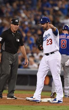 a baseball player standing on top of a field next to a umpire and an umpire