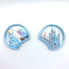 two plastic magnets depicting disney princesses in front of a castle, and an image of cinderella