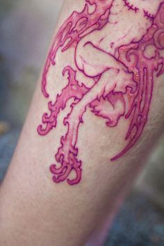 a woman's leg with pink ink on it and an artistic design in the middle