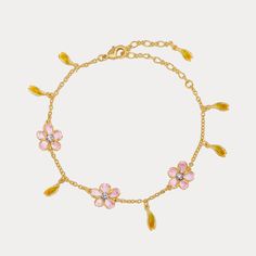 a gold bracelet with pink flowers and yellow leaves on the link, set against a white background