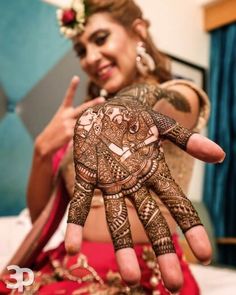 a woman is showing off her henna