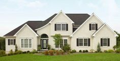 a large white house sitting on top of a lush green field