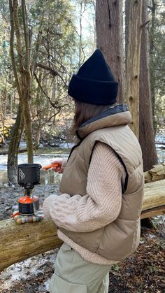 a person standing next to a log in the woods