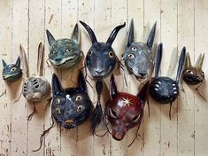 a group of animal masks mounted to the side of a wall