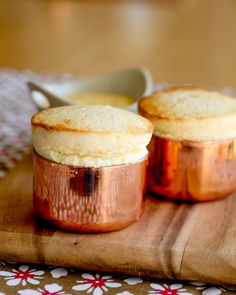 two cupcakes sitting on top of a wooden cutting board