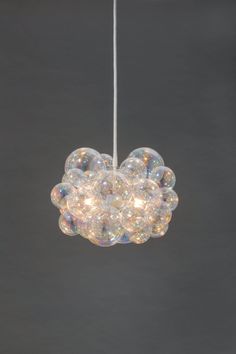 a chandelier with bubbles hanging from it's sides on a gray background