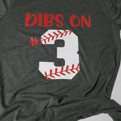 a baseball shirt that says dibs on 3 and has the number three in it