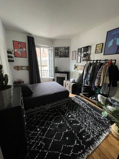 a bedroom with a bed, rug and pictures on the wall above it in front of a window