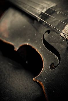 an old violin that is sitting on the ground with it's strings still attached