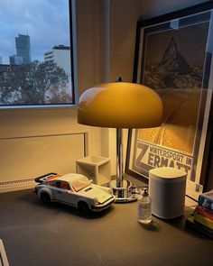 a lamp that is sitting on top of a desk next to a car and other items