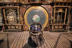 a large metal clock sitting on top of a wooden floor