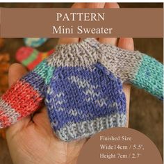 a hand holding a knitted mitt with the text pattern mini sweater on it