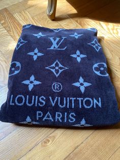 the louis vuitton paris towel is laying on the floor next to a chair