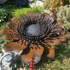 a large metal flower sitting in the grass