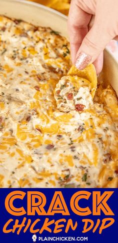 a hand dipping a tortilla chip into a cheesy casserole