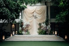 an outdoor stage decorated with flowers and greenery for a wedding ceremony at the four seasons hotel