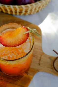 an orange and apple drink on a cutting board