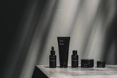 an assortment of skin care products sitting on a countertop in front of a black and white background