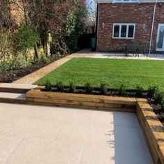 a backyard with grass and wooden steps leading up to the house