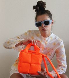 Meet the new, mini version of our Pillow Puffer bag : Baby Pillow Essential bag in gorg neon mandarin 🍊🧡 Also our novelty: from now on your garment will have its own dust bag 🌼 The most huggable piece in your wardrobe. This bag is made of waterproof raincoat fabric with cotton lining. Needless to say this is the epitome of soft & cozy. Perfect piece for everyday life. Bag is equipped with two pockets for small items and convenient handles. Bag size: 20cm x 20 cm (7.8 x 7.8 in); Handle length: Functional Orange Pouch Bag, Trendy Orange Nylon Bag, Modern Orange Square Bag, Orange Nylon Bags For Everyday Use, Orange Bag With Top Carry Handle For On-the-go, Modern Orange Bag With Top Carry Handle, Trendy Orange Tote Bag, Trendy Orange Pouch Bag, Orange Pouch Bag For On-the-go