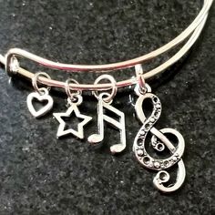 New Music Note Charm Bracelet Adorned With Two Music Note Charms, A Star And A Heart Charm Silver Plated Adjustable Wire Bracelet Fits Wrists 5.5 To 8.5 Inches Ships Within 24 Hours Of Purchase Monday-Saturday Adjustable Silver Jewelry For Concert, Adjustable Silver Jewelry For Concerts, Silver Band Jewelry For Concert, Silver Band Jewelry For Concerts, Silver Band Bracelets For Concerts, Nickel-free Silver Jewelry For Concerts, Adjustable Music-themed Bracelets For Concerts, Adjustable Silver Bracelets For Concerts, Adjustable Metal Music-themed Jewelry