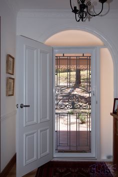 an open door leading to a patio with a wrought iron fence on the front and side