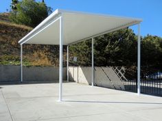 an empty covered parking lot with trees in the background