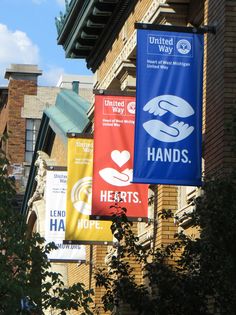 several banners hanging from the side of a building