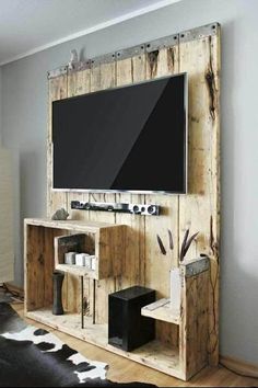 a flat screen tv mounted to the side of a wooden entertainment center in a living room