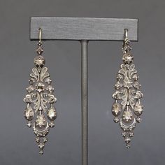 A dramatic and dazzling pair of Catalan drop earrings dating to the early 1800s. Known as 'herring' earrings due to the resemblance of their silhouette to herrings in brine, a popular dish of the region, they are set with a total of 74 diamonds, mainly rose- and table-cuts. The gems are set close-backed, some with crimped collets, and are most likely foiled. Each earring consists of five individually articulated sections which swing with movement and bring sparkle to the diamonds as they catch t Formal Rose Cut Diamond Chandelier Earrings, Formal Chandelier Earrings With Rose Cut Diamonds, Silver Earrings With Intricate Diamond Design, Victorian Chandelier Drop Earrings For Evenings, Victorian Chandelier Drop Earrings For Evening, Victorian Chandelier Earrings For Evening, Antique Chandelier Earrings For Formal Occasions, Victorian Chandelier Earrings For Formal Occasions, Evening Diamond Chandelier Earrings