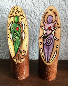 two wooden pegs with painted designs on them