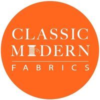 the classic modern fabrics logo on an orange circle with white lettering and a black outline