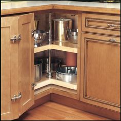 an open cabinet with pots and pans in it