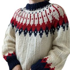 a person wearing a sweater with red, white and blue designs on it