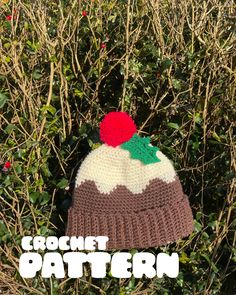 a crochet hat with a red pom - pom on it