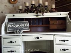 a white desk with some candles on top of it and a sign that says peacemaker's