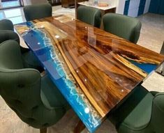 a table that has been made out of wood and glass with green chairs around it