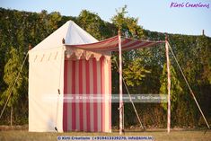 a striped tent is set up in the grass