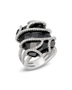 Diamonds encase a large black onyx stone in this white gold statement ring. Black Diamond Rings For Evening, Elegant Black Diamond Ring For Evening, Elegant Black Rings For Evening, Luxury Black Spinel Rings For Formal Occasion, Black Formal Rings In Fine Jewelry Style, Black Onyx Rings With Diamond Accents, Modern Black Rings For Evening, Luxury White Gold Diamond Ring With Black Enamel, Black Fine Jewelry Rings For Formal Occasion