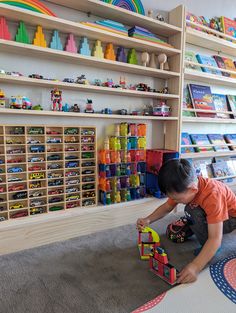 a young boy playing with toys in a playroom at a children's store